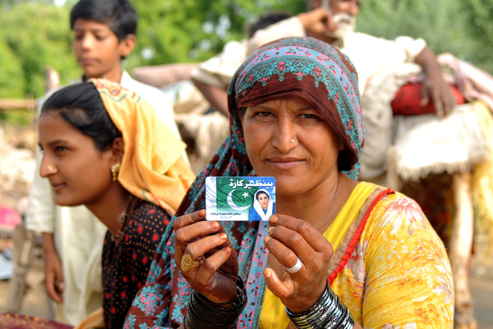 A woman displays her debit card provided under Pakistan’s national income support programme.
